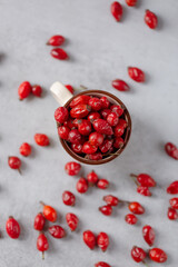 Medicinal plants and herbs. Rose hips berries on concrete background with copy space. Dried fruits for herbal teas and essential oils. Selective focus. Vertical orientation. Flat lay.