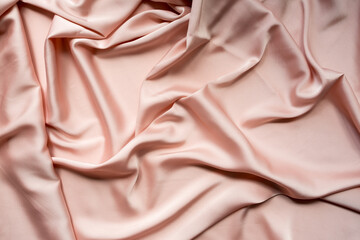 Delicate satin or silk draped fabric pink texture for festive backgrounds