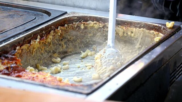 Close up of Mac n cheese being prepared at a street food market stall in Borough Market