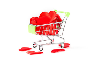 A toy cart from the supermarket filled with red hearts isolated on white