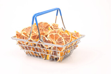 Dried citrus fruits in a market basket on a white background. Vitamin foods