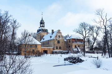 Fototapeta na wymiar The building complex of an old large German manor located in Latvia is snow-covered in winter