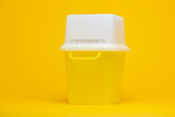 Monochrome syringe pen container with white cap on seamless yellow background for the disposal of used injector needles with drug residue. Studio medical equipment still life concept.