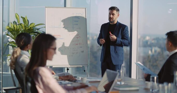 Young Caucasian Handsome Business Boss Leading Corporate Meeting with Finanical Graph Data Chart Information for Planning Management Negotiation.