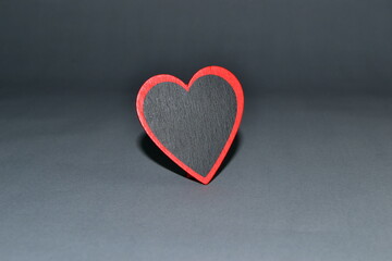 Obraz premium The wooden red heart on a gray background.