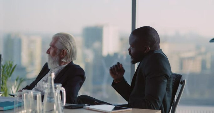 Afro-American Handsome Young Creative Manager Participating in Office Meeting Lecture Raising Hand Asking Question from Boss during Financial Presentation.
