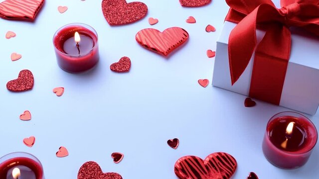 Happy days background. Red love hearts, romantic gift box, Valentines day candle on white table. Romantic message template with copy space.