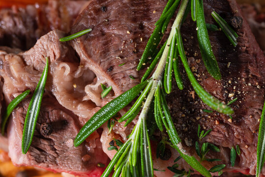 Macro shot of beef steak ribeye with rosemary. Appetizing image for restaurant menu. Delicious food. View from above. Close-up.