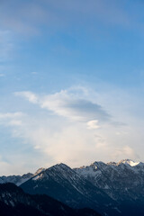 Mountain range around the Schwarzhanskarspitze mountain in vertical format in winter with gentle soft clouds and blue sky