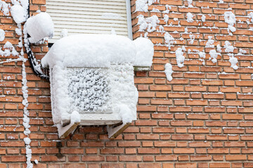 snow covered air conditioning outdoor unit