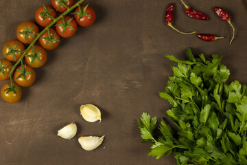 food frame composition with Italian ingredients. cherry tomato, red hot chili pepper, parsley on wood background