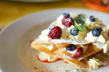 Apple berries crumble cake with whipped cream in restaurant - closeup macro