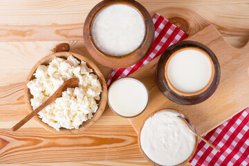 Milk in various dishes on the old wooden table. village dairy products