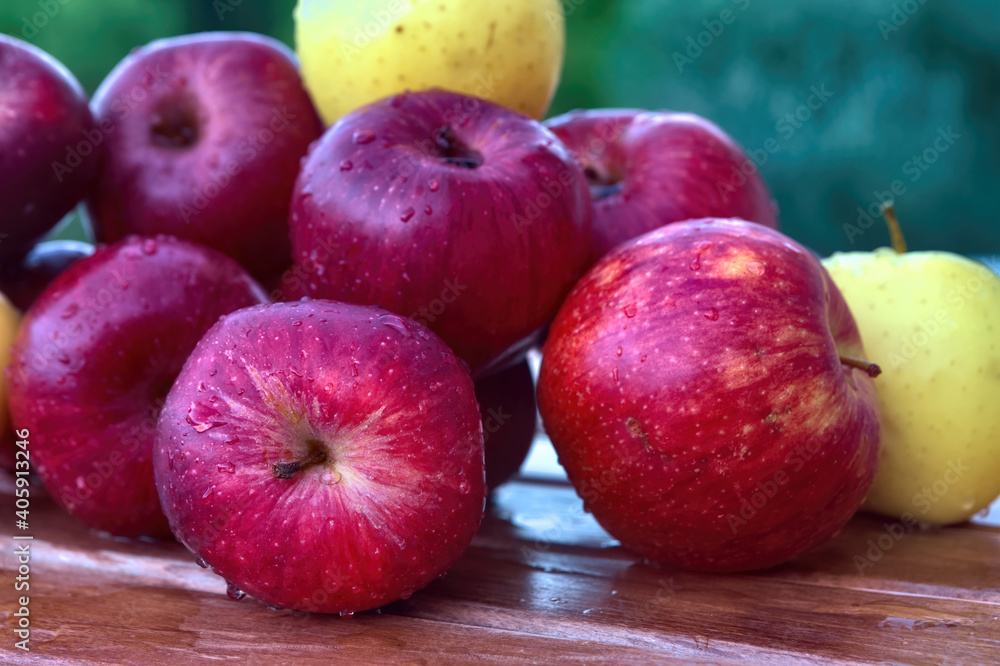 Sticker closeup shot of red and yellow apples with water drops on a wooden table