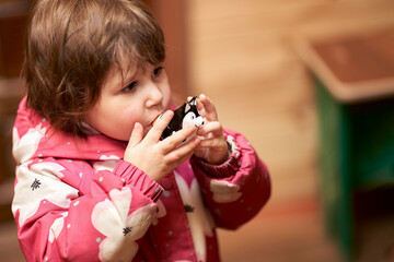 Pottery workshop. A little girl blows a ceramic whistle made in the form of a husky dog. Selective focus. Copy space.