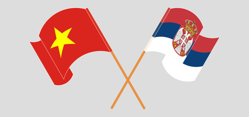 Crossed and waving flags of Vietnam and Serbia