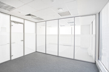 Empty office room with glass walls, door and glass window