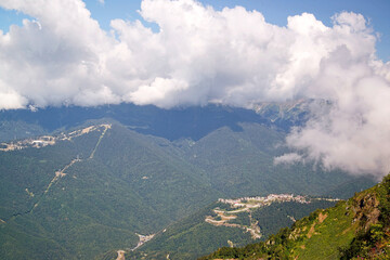 View of the mountains, overgrown with dense deciduous and coniferous forests, with modern transport and economic communications for the active recreation of people