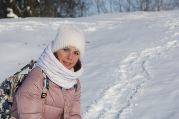 Fototapeta na wymiar Woman in winter clothes on a walk in the park. There is a lot of snow around.