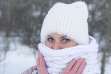 Portrait of a girl in winter clothes. In the winter park. Face close-up.