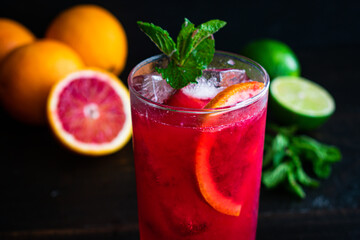 Blood Orange and Raspberry Mojito: A rum cocktail with blood orange, raspberries, lime, and mint leaves served in a tall glass over ice	