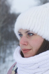 Portrait of a girl in winter clothes. In the winter park. Face close-up.