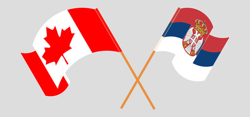 Crossed and waving flags of Canada and Serbia