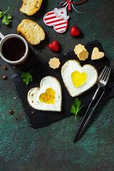 Breakfast on Valentines Day or brunch. Heart shape fried egg on slate plate.  Top view flat lay. Free space for your text.