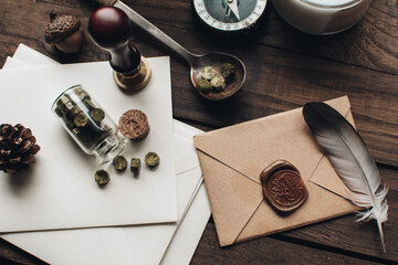 Letter seal with wax seal stamp on the wood table. Vintage notary stamp and sealed envelope. Post concept. Sealing wax. Wax seal. Dark academia style. Scandinavian hygge styled composition.