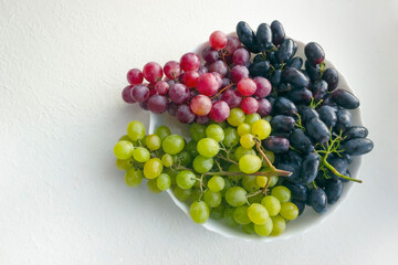 colorful grapes on a white plate. stock photo
