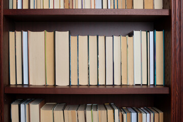 Bookshelf with books displayed backwards.