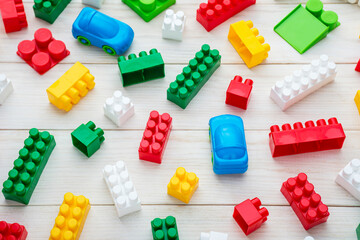 Colorful plastic toy blocks. Colorful plastic toy blocks on white wooden background. Top view. Baby background