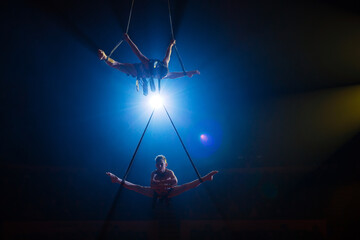 Circus actress acrobat performance. Two boys perform acrobatic elements in the air.