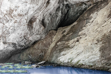 A cleft in the rock. Concept archaeology, geology, research and excavation. Lake with clean and blue water.