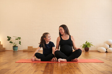 Mother and daughter meditating in a yoga studio
