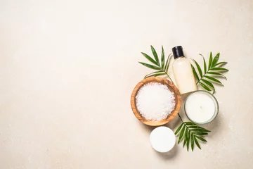 Fotobehang Spa background. Spa product composition with palm leaves, cosmetic and sea salt at stone table. Flat lay image. © nadianb