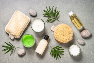 Obraz na płótnie Canvas Spa product composition with cosmetics, sea salt, towel and palm leaves at stone table. Flat lay image with copy space.