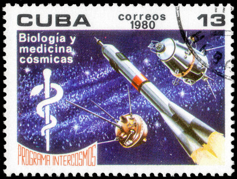 Postage stamp issued in the Cuba the image of the Staff of Aesculapius, rocket and satellites. From the series on Intercosmos Program, circa 1980