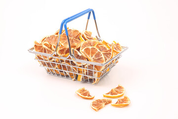 Dried citrus fruits in a market basket on a white background. Vitamin foods