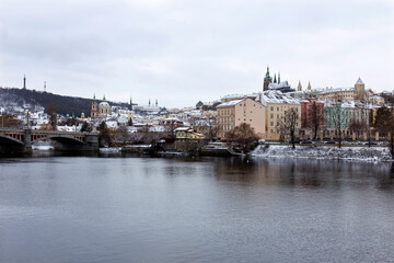 Fototapeta premium Snowy Prague Lesser Town with Prague Castle above River Vltava, Czech republic
