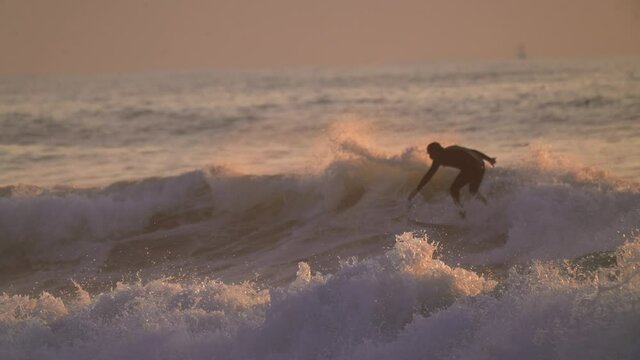 This slow motion video follows a surfer shredding through rough waves and wiping out into the vast ocean. 