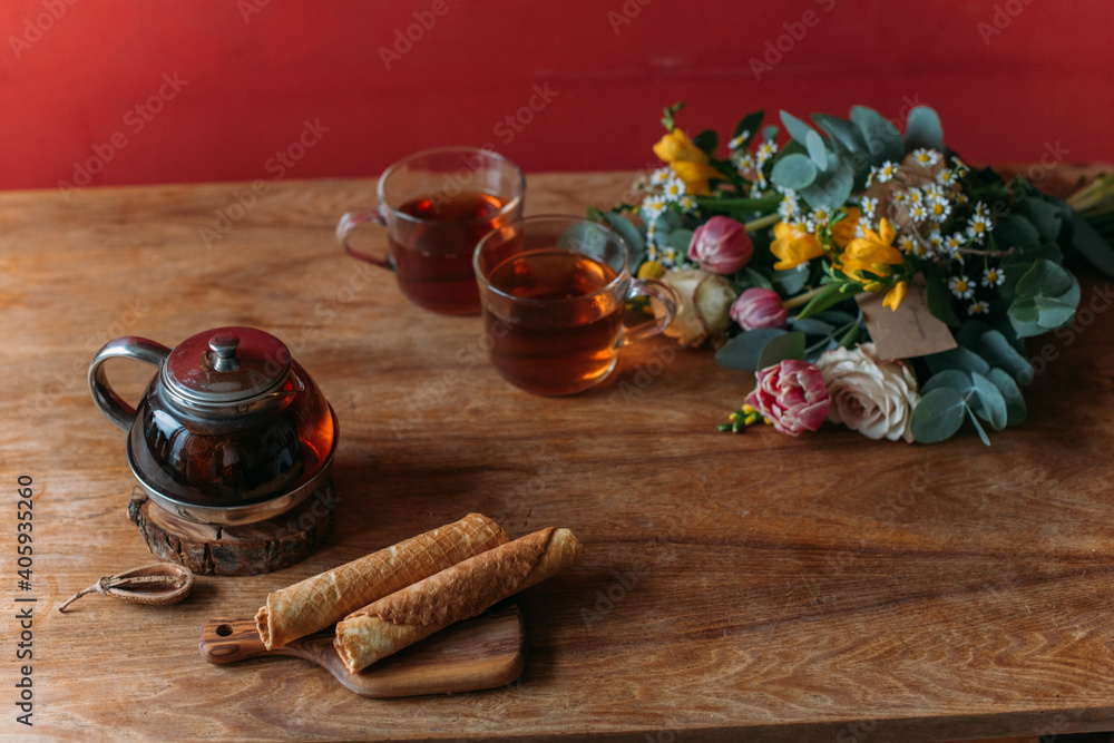 Wall mural Still life. A table with a teapot, mugs and flowers