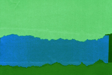 Green torn paper collage close-up. Texture made from various paper and cardboard parts. Damaged old...