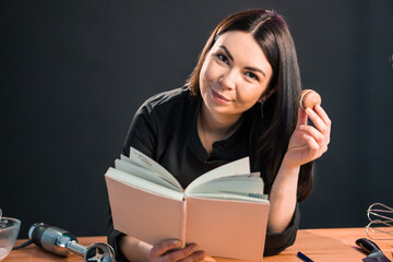 Beautiful female looking for macaroon recipe in the cook book.