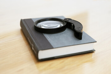 An old magnifying glass lies on the book