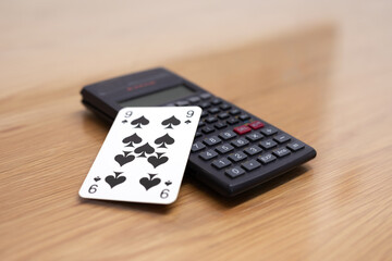 Calculator and playing card black spades nine