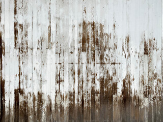 old farm barn wall with fading peeling white paint