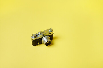 Top view of an old model manual film camera isolated on a yellow background. Flat lay. Copy space