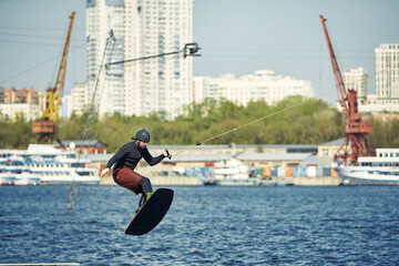 Young man riding wakeboard on a summer lake