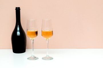 two champagne glasses and bottle on pink background with copy space, valentines day, new year, honeymoon concept